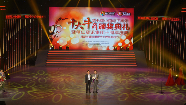 颁奖嘉宾为本届的十大牛商，富轩门窗董事长李昌安颁发奖杯与鲜花